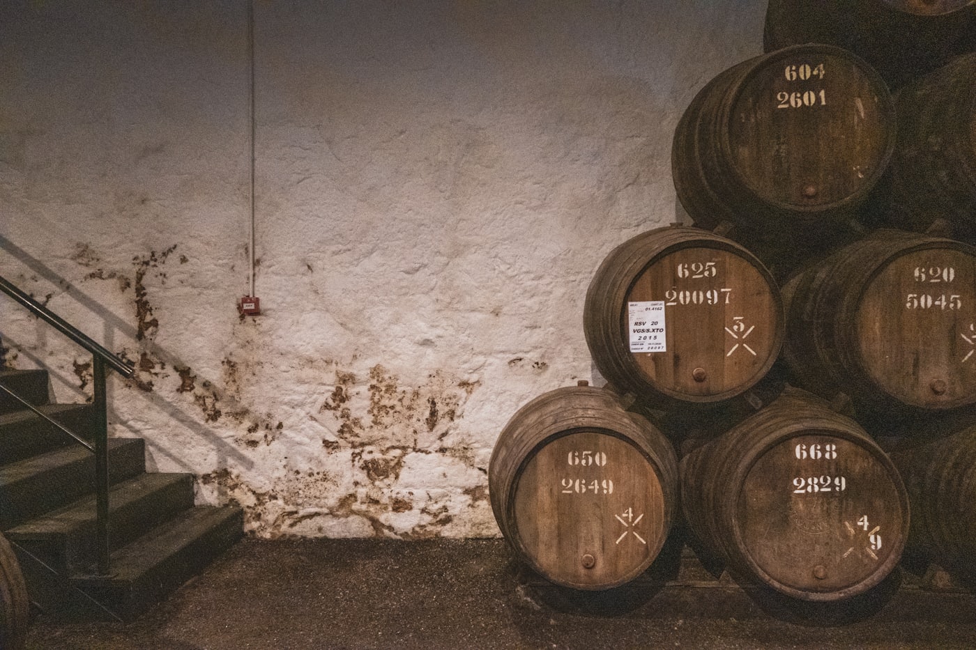 Oak barrels stacked in a cellar, showing tight wood grain
