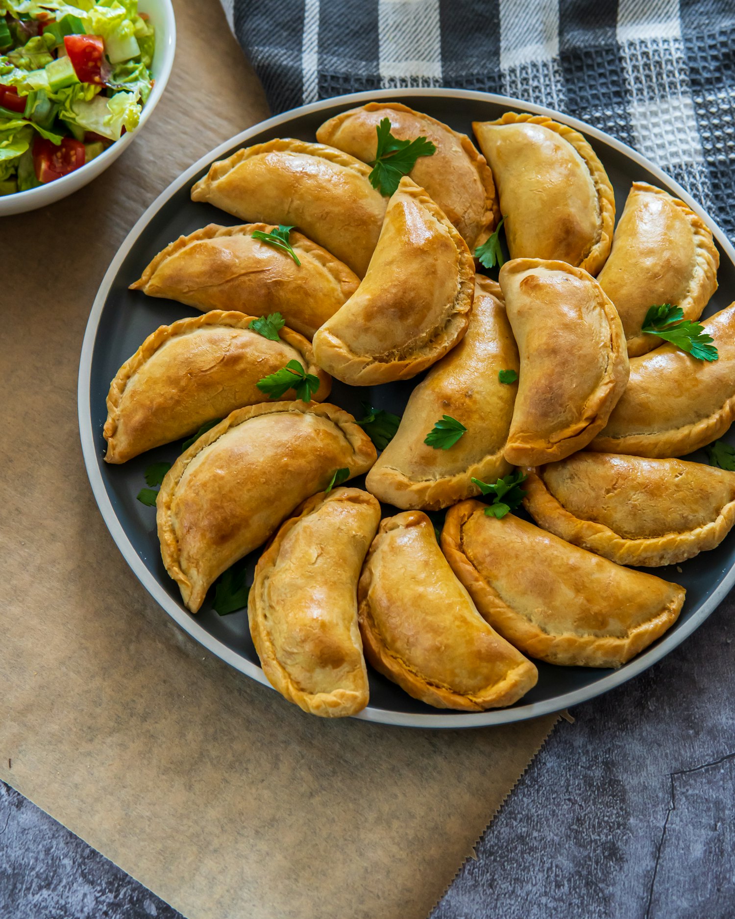 Golden hand-folded Argentine empanadas on a plate